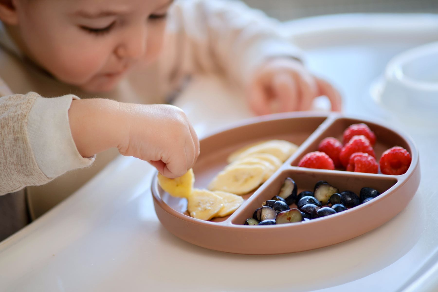 Baby lernt selbstständig zu essen, Übergang zu fester Nahrung, schrittweiser Leitfaden für Eltern, kindergerechtes Essgeschirr.