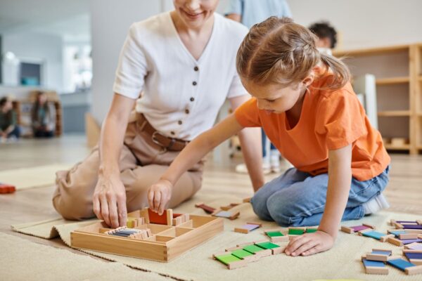 Kind lernt mit Montessori-Materialien zu Hause unter Anleitung einer Erwachsenen für eine unabhängige Entwicklung