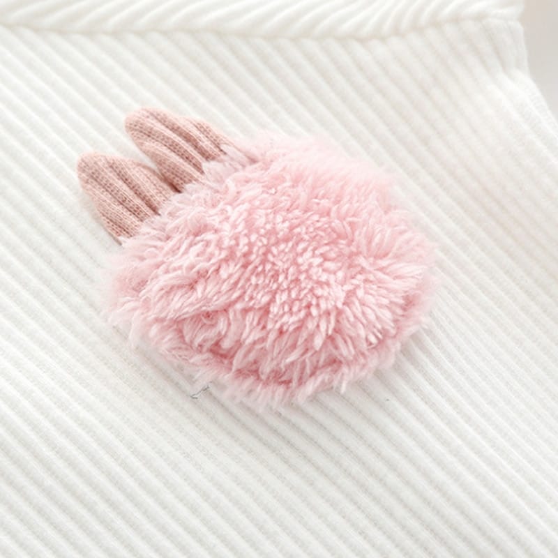 Detailansicht des flauschigen Plüschhasen-Applikation auf weißem Baumwoll-Bodysuit, sanft für Babyhaut.