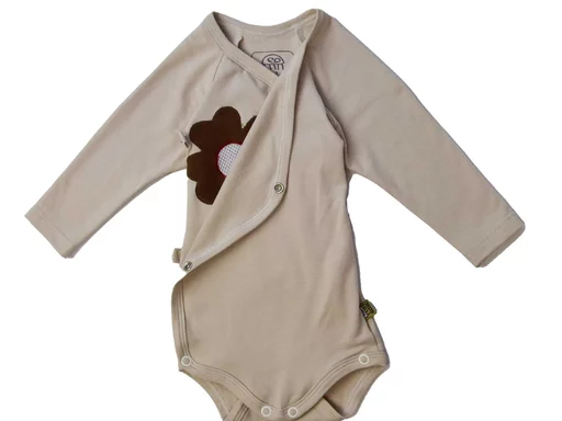 Dieser natürliche beige Baby Wickelbody aus weichem Bambusgewebe ist mit einer speziellen Blumenapplikation ausgestattet, die zur Befestigung der 'MARY by sticklett' Sensoreinheit dient. Die smarte Integration der Technologie mit sanftem Material und praktischem Design macht diesen Body ideal für moderne Eltern, die Komfort und Überwachung ihrer Babys verbinden möchten.