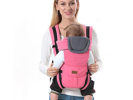 unge Mutter mit atmungsaktivem Babytrage-Rucksack in Pink, der das Baby sicher und komfortabel hält.