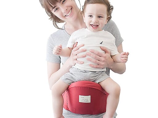Lächelnde Mutter mit ergonomischem Babytrage-Hüftgurt und glücklichem Kleinkind darauf.